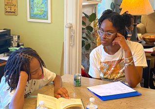 college student reading with younger student.
